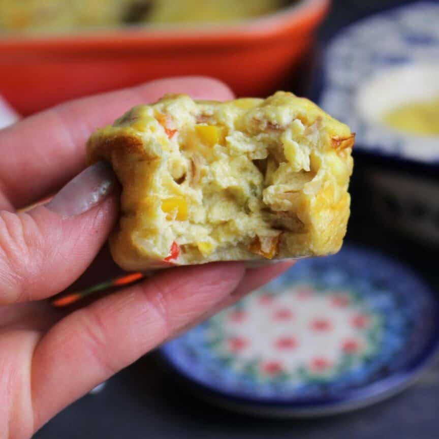 Green chili crustless quiche baked in a muffin tin with a big bite taken out of it.