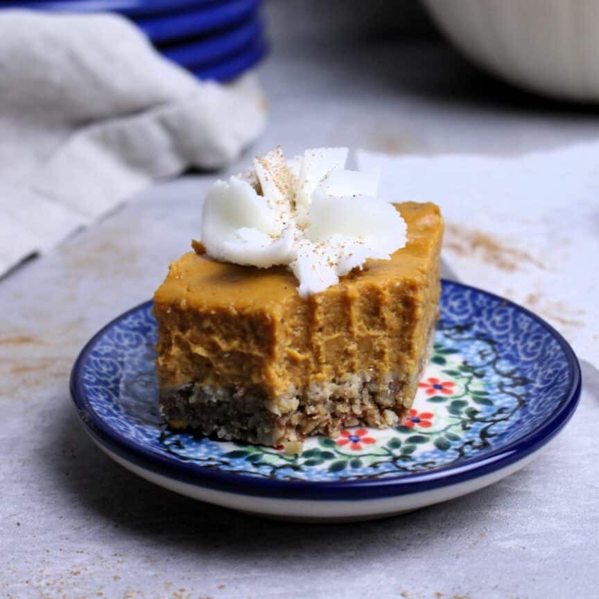 Creamy pumpkin pie bars with oat crust plated and a bit missing.