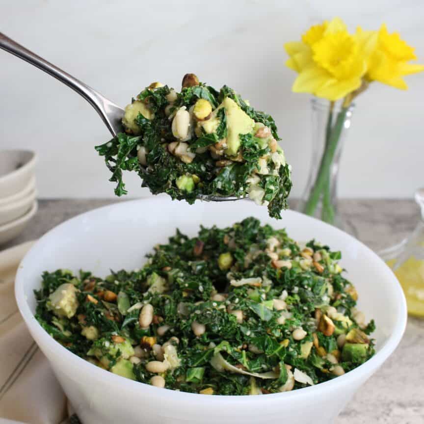 Serving spoon of warm white bean kale salad.