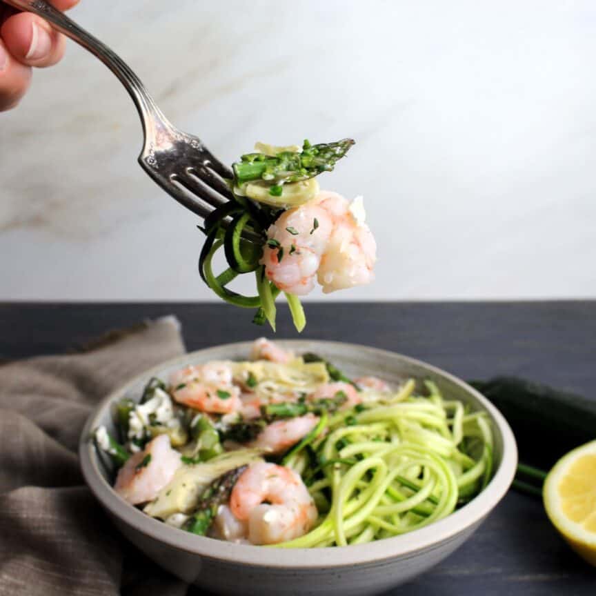 Fork full of delicious shrimp, artichoke, asparagus and goat cheese.
