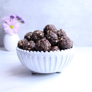 Peanut butter date balls rolled up and placed in bowl.
