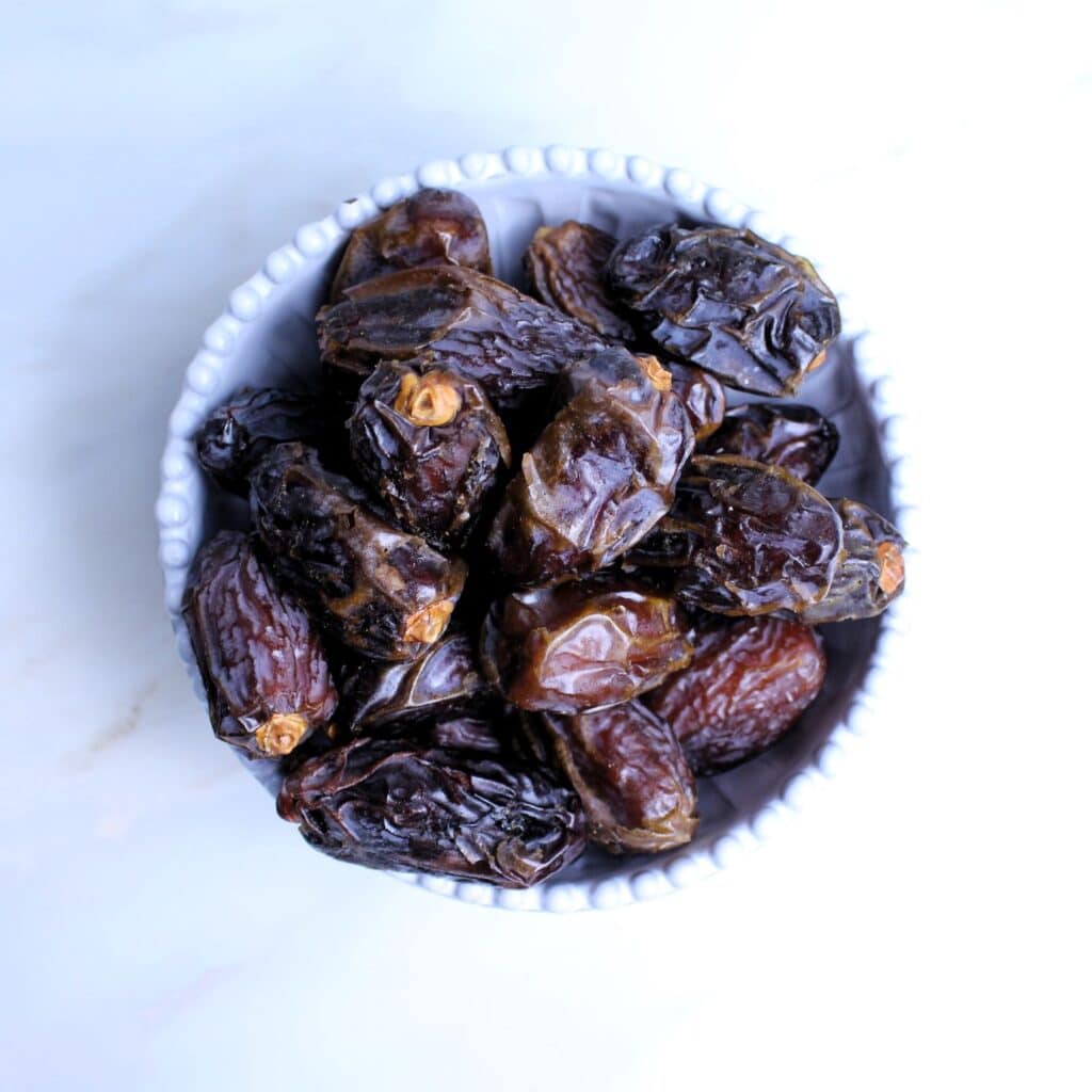 Bowl full of whole medjool dates.