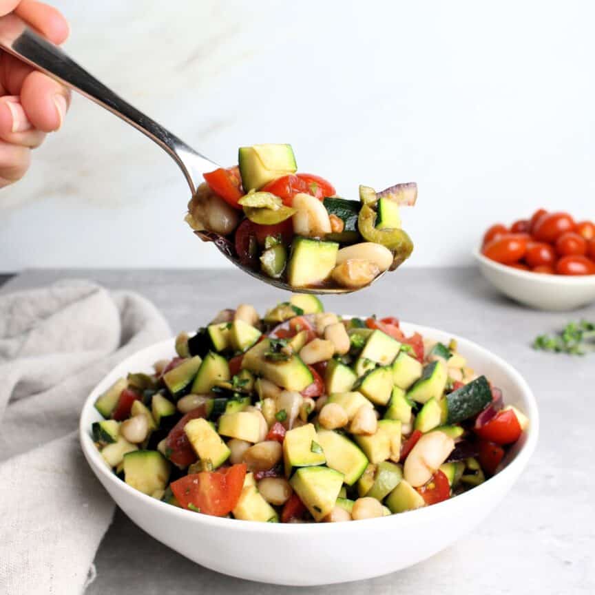 Serving of Tuscan salad with white beans, tomatoes, and zucchini.